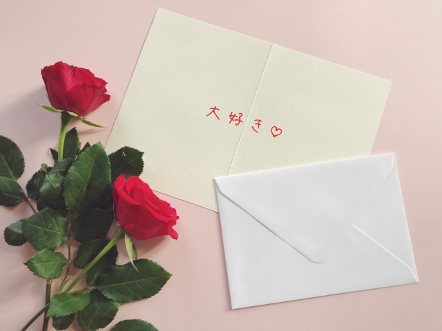 赤い薔薇と大好きと書いてあるラブレター